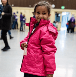 a little girl in a pink coat