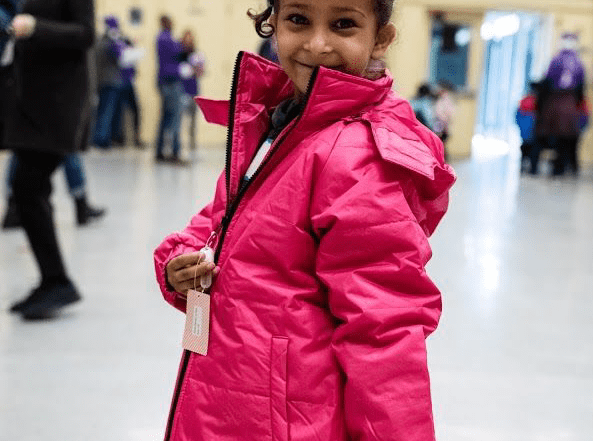 a little girl in a pink coat